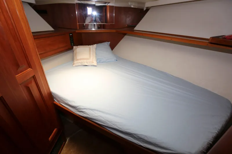 Slide: The Image of Cozy cabin interior of 1991 Viking 50 Convertible yacht with wooden accents and a neatly made bed. - 39
