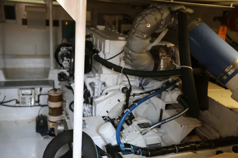 Slide: The Image of Engine room of a 1991 Viking 50 Convertible yacht, showcasing mechanical components and piping. - 43