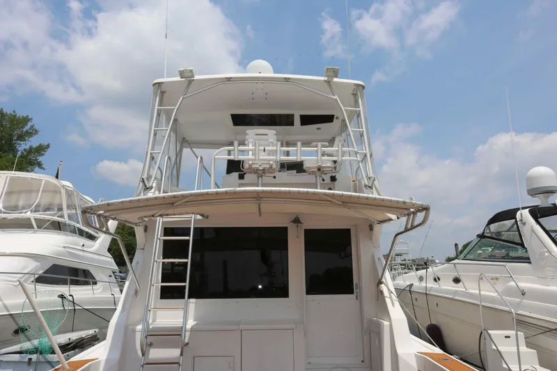 Slide: The Image of 1991 Viking 50 Convertible yacht docked, rear view with ladder and upper deck. - 7
