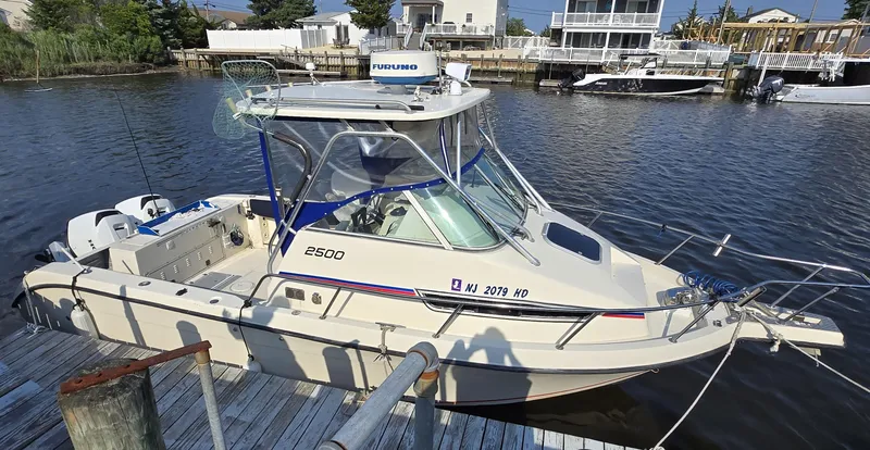 The Image of 1996 Stratos 2500 Walkaround boat docked in a marina, featuring a sleek design. - 0