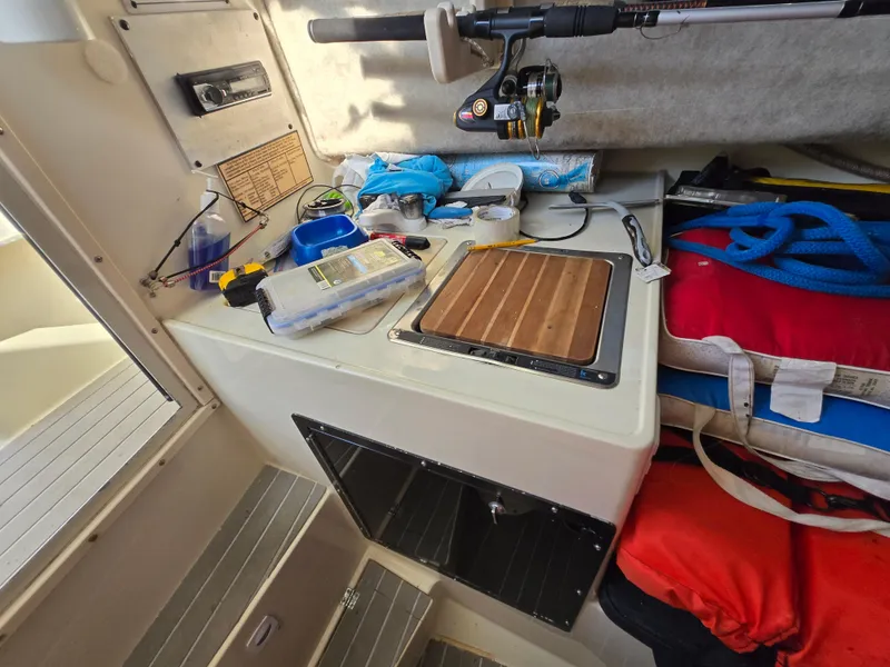 Slide: The Image of Interior of a 1996 Stratos 2500 Walkaround boat with fishing gear and supplies. - 11