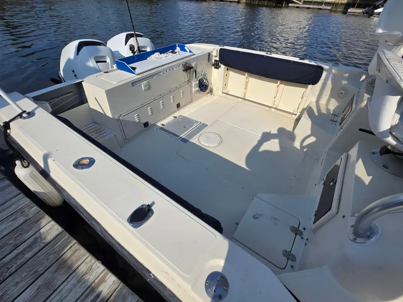 Slide: The Image of 1996 Stratos 2500 Walkaround boat interior with dual engines, docked by the water. - 5