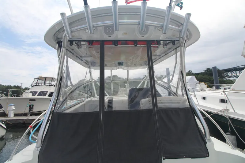 Slide: The Image of 2007 Sailfish 3006 WALKAROUND boat docked, featuring a covered cockpit area. - 10