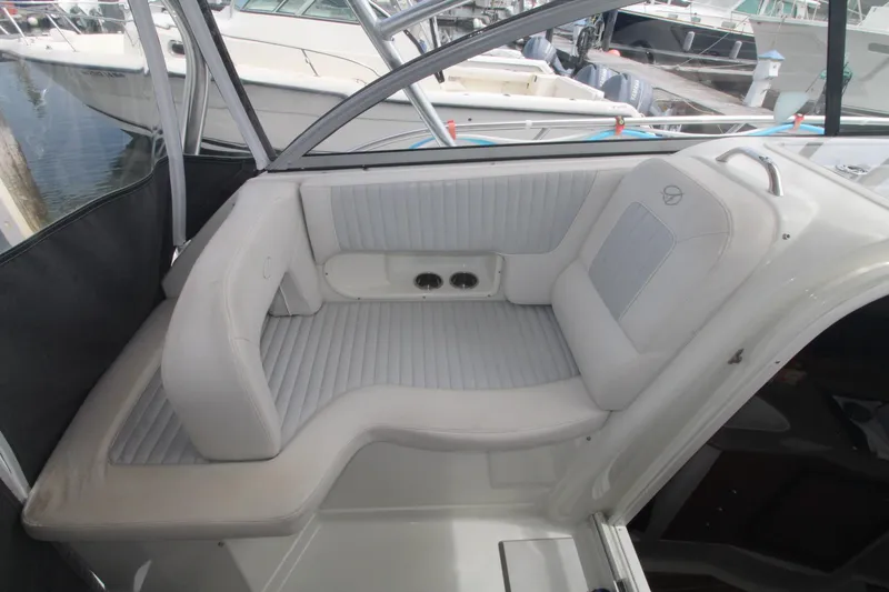 Slide: The Image of 2007 Sailfish 3006 WALKAROUND boat interior with cushioned seating and docked boats in background. - 12