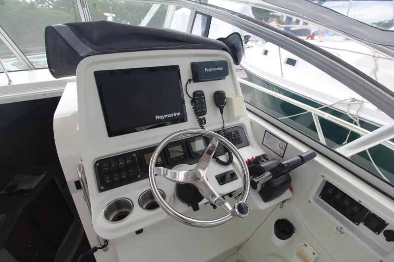 Slide: The Image of 2007 Sailfish 3006 WALKAROUND boat helm with Raymarine electronics and steering wheel. - 17
