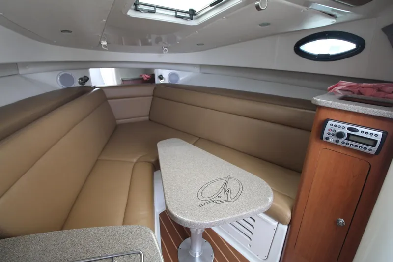Slide: The Image of Interior of 2007 Sailfish 3006 WALKAROUND boat with tan seating and compact table. - 19