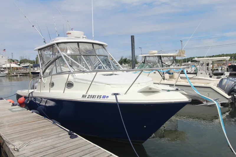 Slide: The Image of 2007 Sailfish 3006 WALKAROUND boat docked at marina, featuring sleek design and fishing rods. - 2