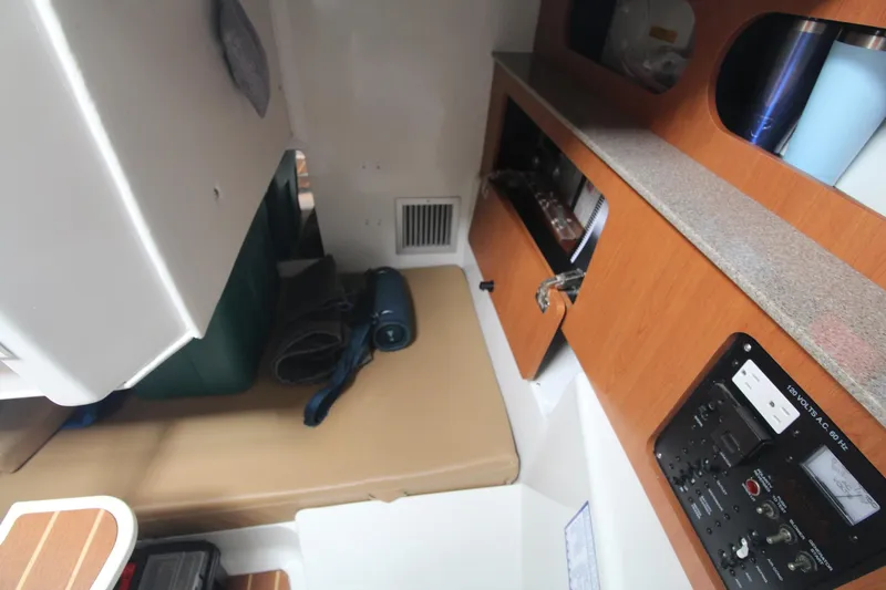 Slide: The Image of 2007 Sailfish 3006 WALKAROUND cabin interior with storage, control panel, and seating area. - 22