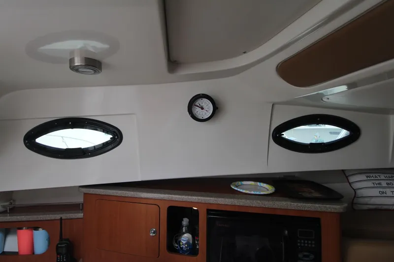 Slide: The Image of Interior of 2007 Sailfish 3006 WALKAROUND boat with portholes and wooden cabinetry. - 23