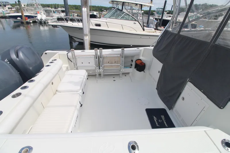 Slide: The Image of 2007 Sailfish 3006 WALKAROUND boat interior at marina, featuring seating and storage. - 4