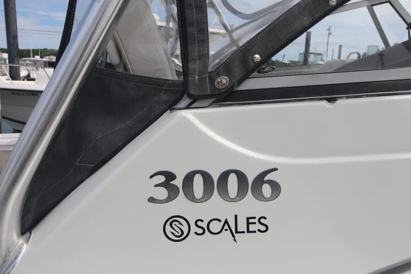Slide: The Image of 2007 Sailfish 3006 WALKAROUND boat detail with Scales logo, docked. - 6