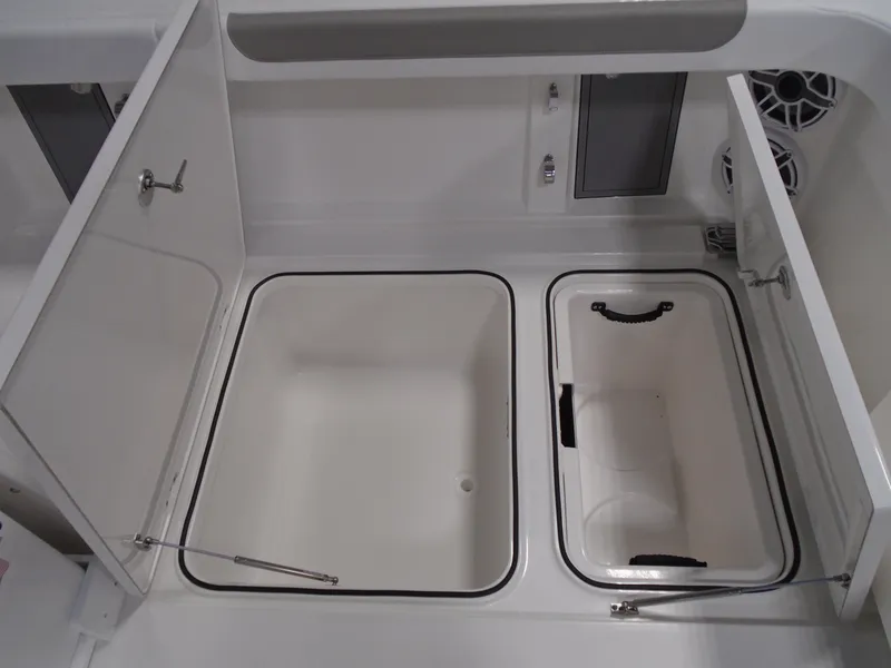Slide: The Image of 2026 Caymas 34 CT boat storage compartments with open lids, showcasing spacious interior design. - 22