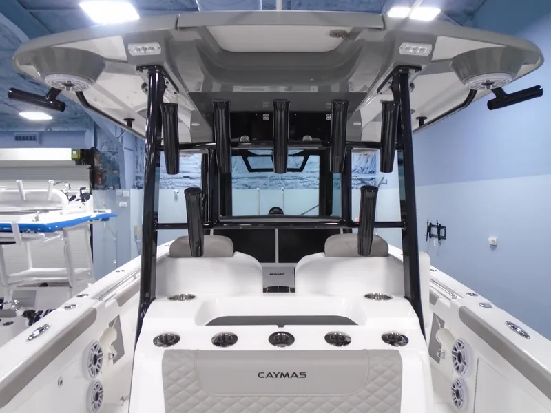 Slide: The Image of 2026 Caymas 34 CT boat interior with rod holders and seating in showroom. - 24