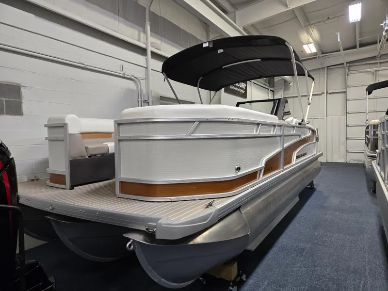 Slide: The Image of 2025 Princecraft Vectra 23 WRL pontoon boat in showroom, featuring sleek design and canopy. - 16