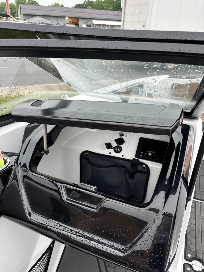 Slide: The Image of 2024 Scarab 215 H.O. Platinum boat dashboard with storage compartment and controls. - 5