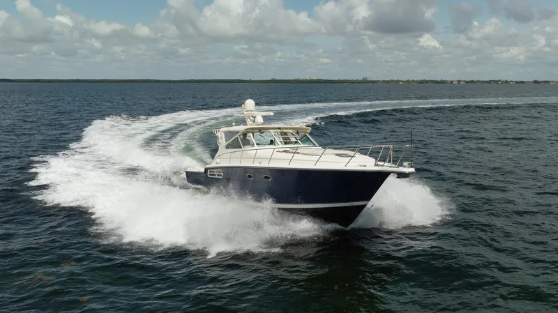 Slide: The Image of 1998 Tiara Yachts 4300 Open cruising on open water under a cloudy sky. - 1