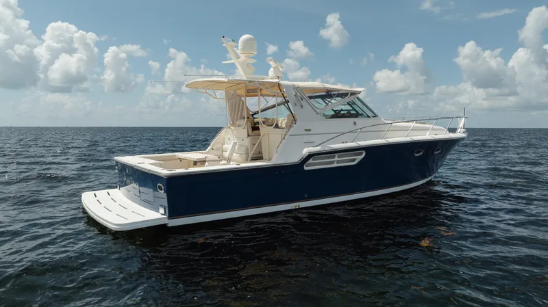 Slide: The Image of 1998 Tiara Yachts 4300 Open on calm ocean waters under a cloudy sky. - 13