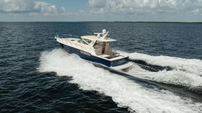 Slide: The Image of 1998 Tiara Yachts 4300 Open cruising on open water under a cloudy sky. - 15
