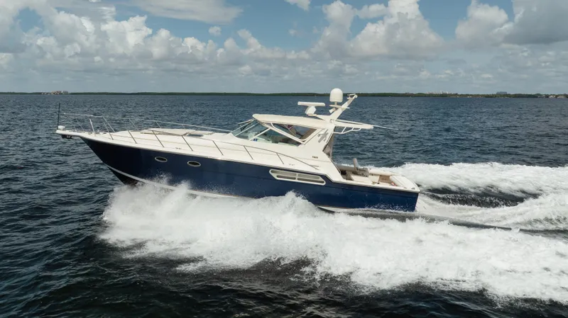 Slide: The Image of 1998 Tiara Yachts 4300 Open cruising on open water under a cloudy sky. - 16