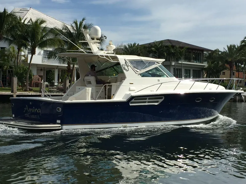 Slide: The Image of 1998 Tiara Yachts 4300 Open cruising on a sunny day near waterfront homes. - 20