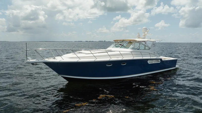 Slide: The Image of 1998 Tiara Yachts 4300 Open cruising on calm ocean waters under a cloudy sky. - 3