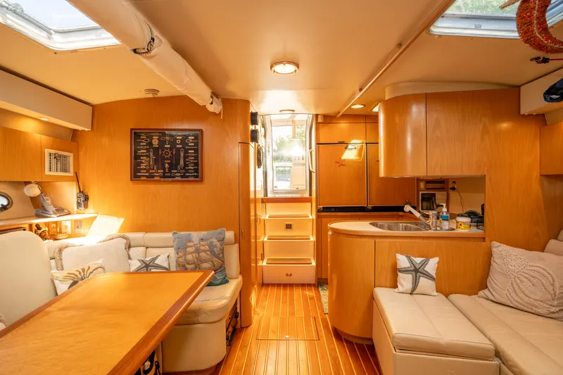 Slide: The Image of Interior of 1998 Tiara Yachts 4300 Open, featuring cozy seating and wooden cabinetry. - 38