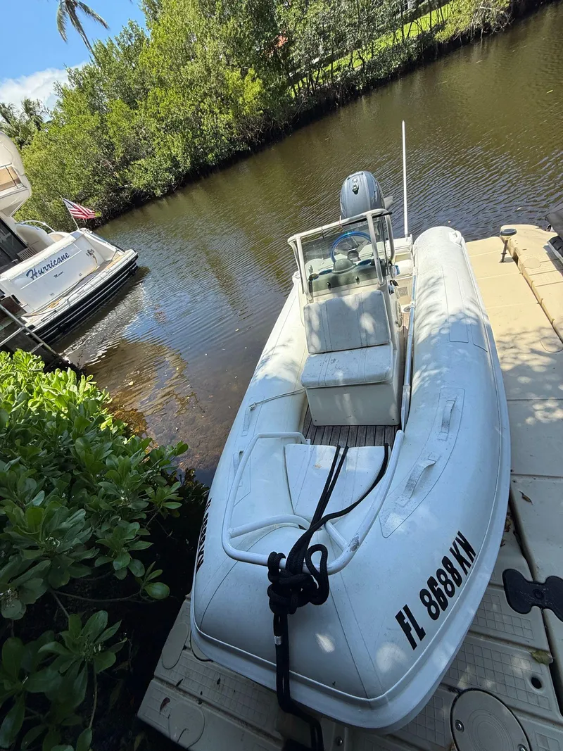 Slide: The Image of White inflatable boat docked beside a Tiara Yachts 4300 Open, 1998 model, on a sunny day. - 39