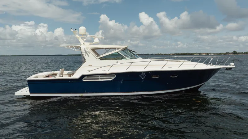 Slide: The Image of 1998 Tiara Yachts 4300 Open cruising on a calm sea under a cloudy sky. - 4