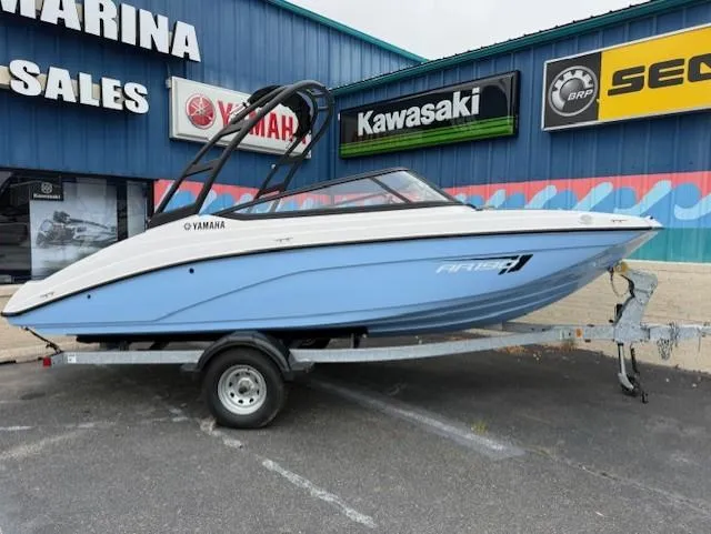 The Image of 2025 Yamaha AR190 boat on trailer at dealership, featuring sleek design and blue hull. - 0