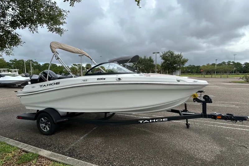 The Image of 2025 Tahoe 200 S boat on trailer in parking lot under cloudy sky. - 0