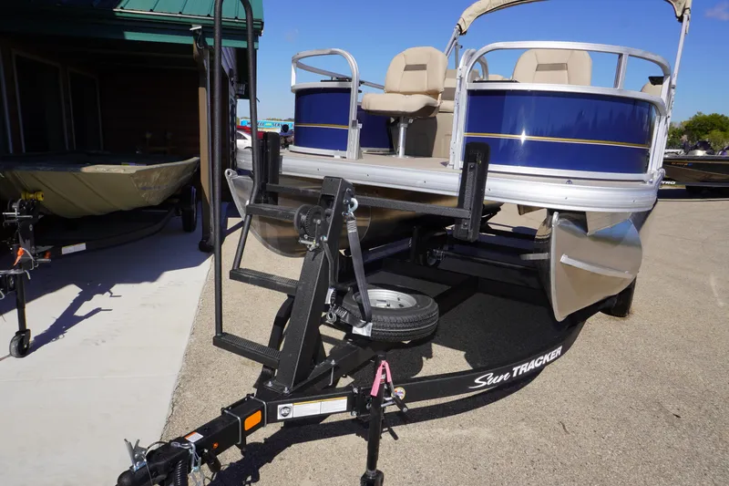 Slide: The Image of 2025 Sun Tracker Bass Buggy 16 XL Select pontoon boat on trailer, outdoor display. - 6