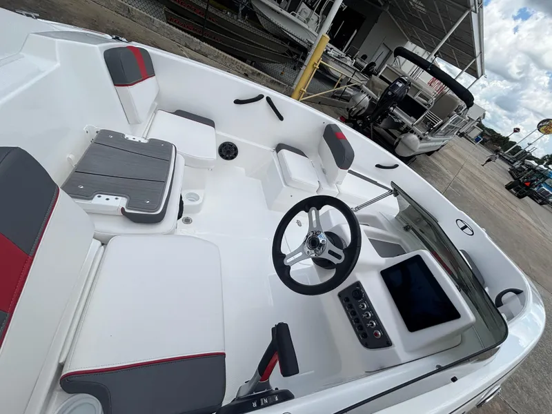 Slide: The Image of 2025 Tahoe T16 boat interior with modern steering and seating, docked outdoors. - 5