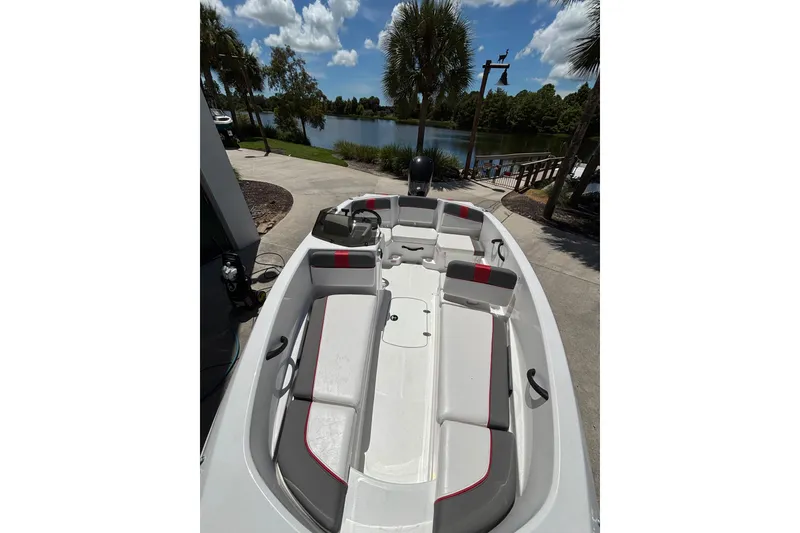 Slide: The Image of 2025 Tahoe T16 boat interior with seating, docked by a scenic lake. - 9