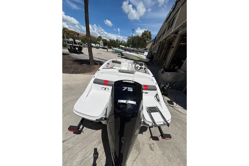 Slide: The Image of 2025 Tahoe T16 boat with Mercury 75 engine, parked outdoors under a clear blue sky. - 3