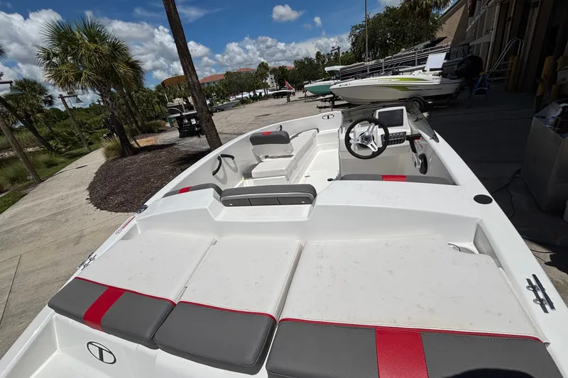 Slide: The Image of 2025 Tahoe T16 boat with sleek design, red and gray seating, parked outdoors. - 7