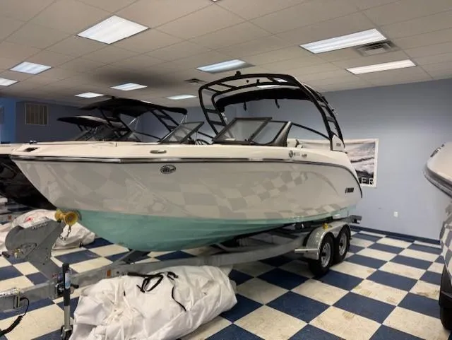 Slide: The Image of 2025 Yamaha Boats 222S on trailer in showroom with checkered floor. - 2
