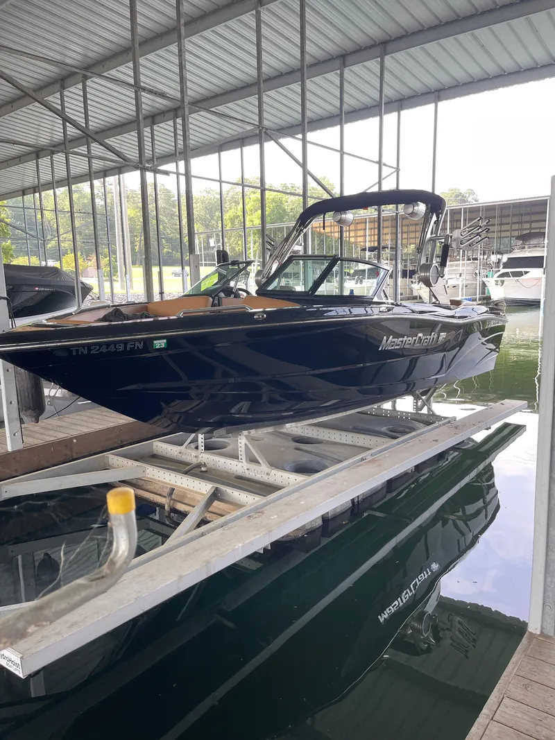 The Image of 2020 MasterCraft XT23 boat docked in a covered marina. - 1