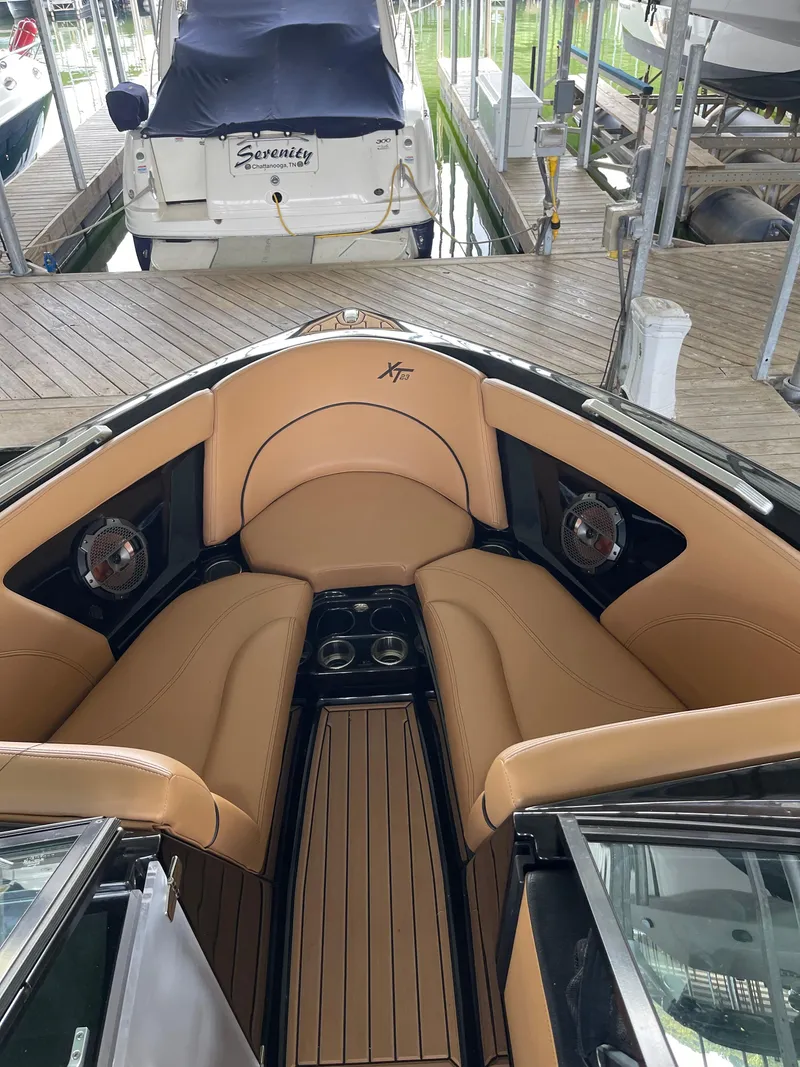 Slide: The Image of 2020 MasterCraft XT23 boat interior with tan leather seating and cup holders. - 6