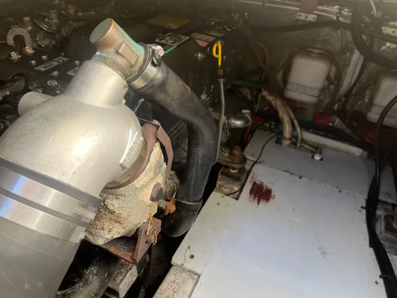 Slide: The Image of Engine compartment of a 1989 Tiara Yachts 33OPEN, showing pipes and mechanical components. - 12