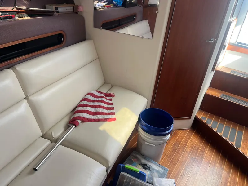 Slide: The Image of Interior of 1989 Tiara Yachts 33OPEN with white seating, flag, and cleaning supplies. - 14
