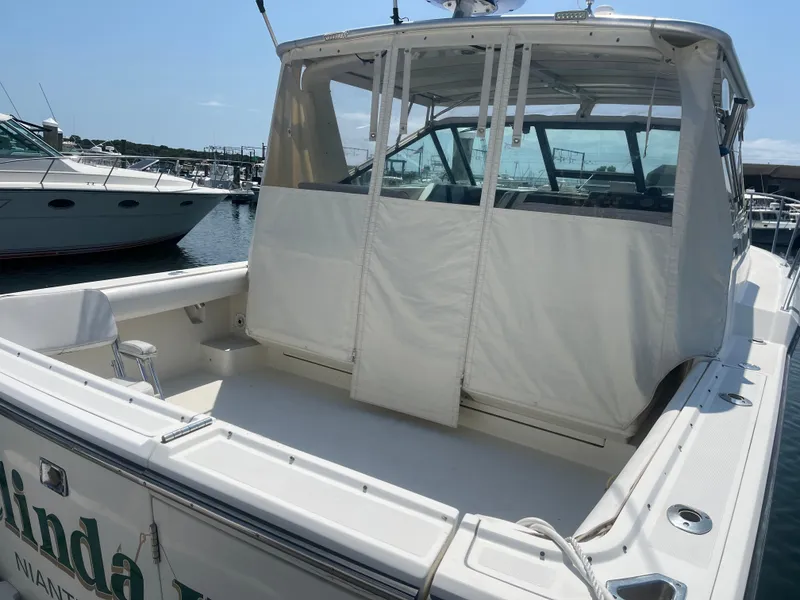 Slide: The Image of 1989 Tiara Yachts 33OPEN boat docked, featuring a covered cockpit area. - 4