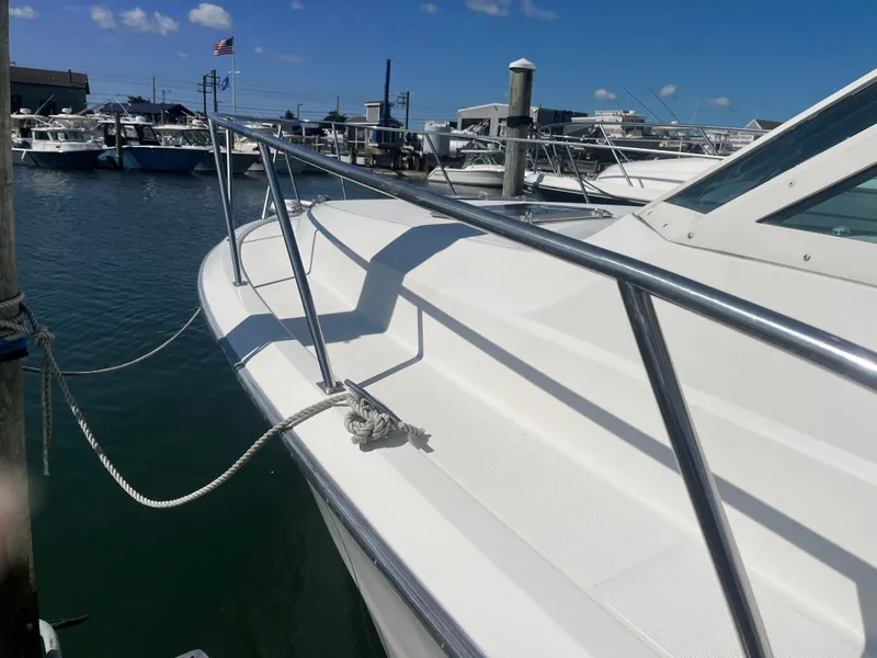 Slide: The Image of 1989 Tiara Yachts 33OPEN docked, showcasing sleek white deck and stainless steel railings. - 5