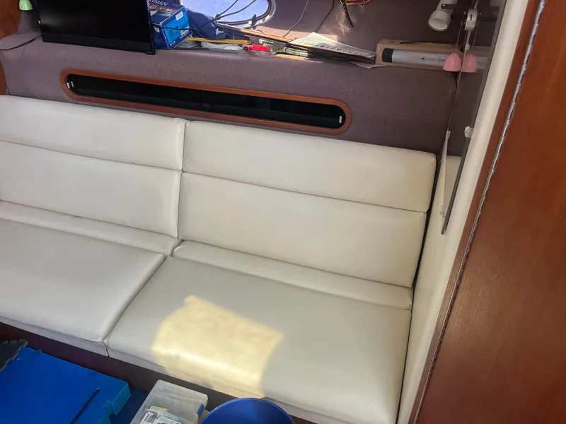 Slide: The Image of Interior of 1989 Tiara Yachts 33OPEN with white leather seating and storage area. - 9