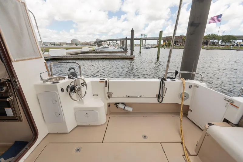 Slide: The Image of 2017 Ranger Tugs R-31 CB boat cockpit with steering wheel, docked at marina. - 3