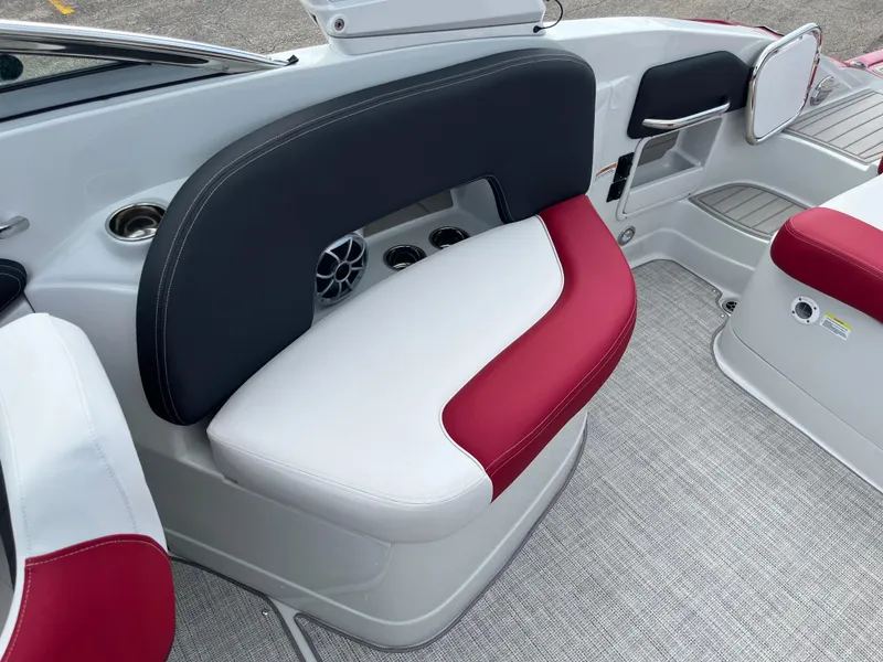 Slide: The Image of 2026 Crownline 298 SS boat interior with red and white seating, cup holders, and speaker. - 12