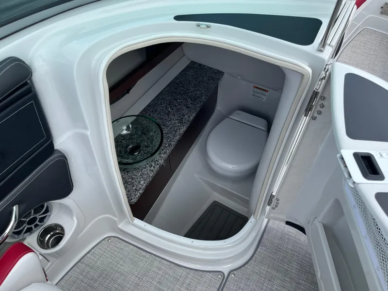 Slide: The Image of Interior of 2026 Crownline 298 SS boat featuring a compact bathroom with modern amenities. - 17
