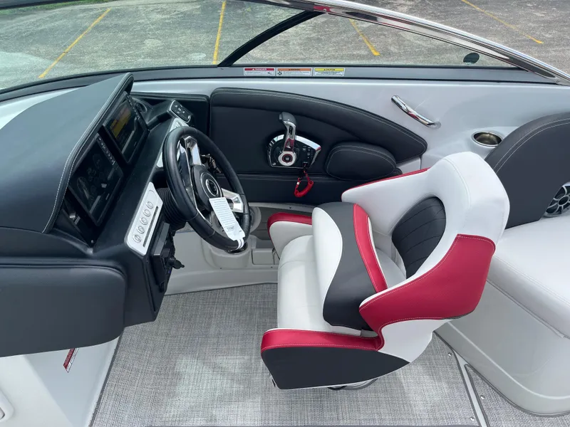 Slide: The Image of 2026 Crownline 298 SS boat cockpit with modern steering and red-accented captain's chair. - 18