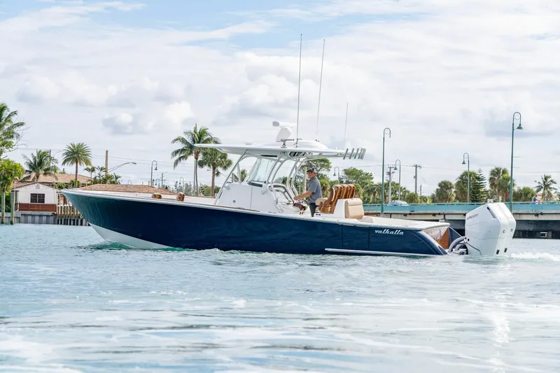 Slide: The Image of 2026 Valhalla Boatworks V-33 cruising on a sunny day near a bridge. - 2