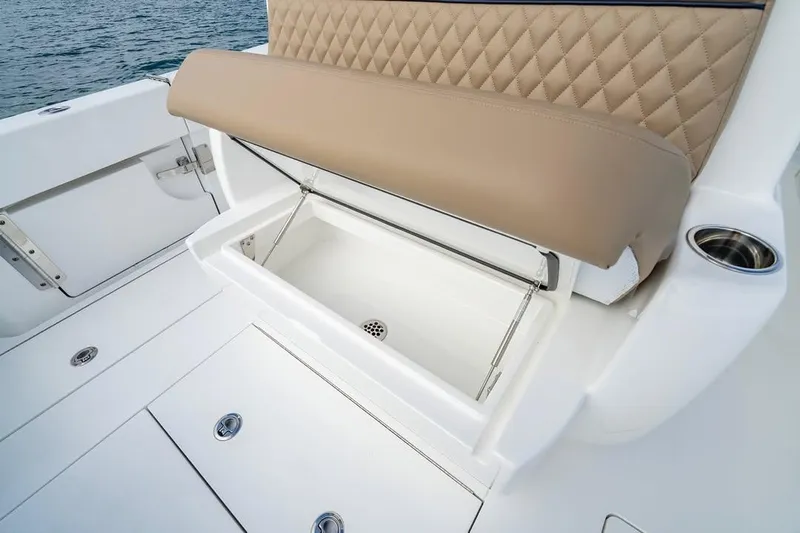 Slide: The Image of 2026 Valhalla Boatworks V-33 with open storage compartment and tan cushioned seating. - 8