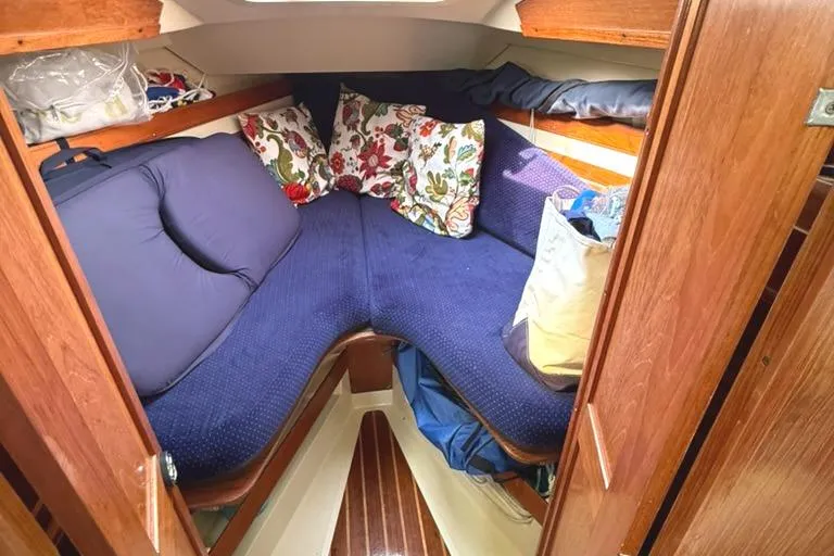 Slide: The Image of Cozy cabin interior of 1986 Pearson 33-2 sailboat with blue cushions and floral pillows. - 16